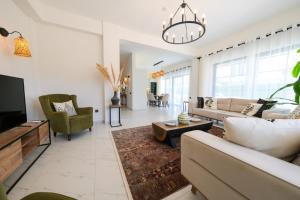 a living room with a couch and a tv at Lily of the Valley Luxury Villa Fethiye, Yesiluzumlu by Sunworld Villas in Fethiye