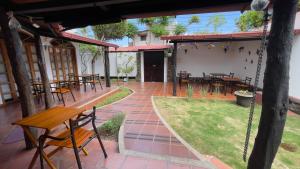 un patio con mesas, sillas y un columpio en Hotel Galapagos Suites B&B, en Puerto Ayora