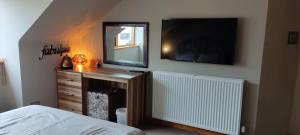 a bedroom with a bed and a mirror and a dresser at Rooms at No 9 The Cooperage in Auchleven