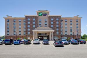 a large building with cars parked in a parking lot at Holiday Inn Express Hotel & Suites Waterloo - St. Jacobs Area, an IHG Hotel in Waterloo