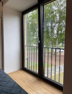 a room with a sliding glass door with a balcony at Apartment by seaside in Ķesterciems +1 photo