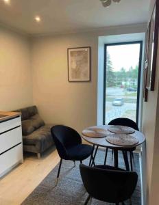 a living room with a table and chairs and a couch at Apartment by seaside in Ķesterciems