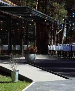 a patio with tables and chairs and ailion with lights at Apartment by seaside in Ķesterciems