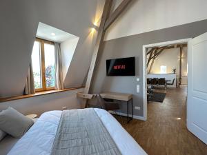 Schlafzimmer mit einem Bett, einem Schreibtisch und einem TV in der Unterkunft TRULY - Viel Platz für Business & Familie - Modern, Garage, Fahrstuhl in Augsburg