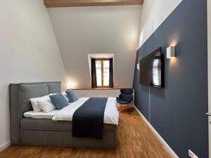Schlafzimmer mit einem Bett mit blauem Akzent in der Unterkunft TRULY - Viel Platz für Business & Familie - Modern, Garage, Fahrstuhl in Augsburg