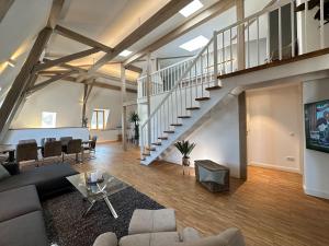 ein Wohnzimmer mit einem Sofa und einer Treppe in der Unterkunft TRULY - Viel Platz für Business & Familie - Modern, Garage, Fahrstuhl in Augsburg