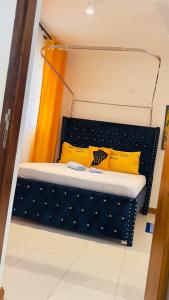 a bed in a room with yellow pillows on it at The Pontoons Nyali A103 in Mombasa