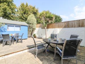 eine Terrasse mit Tisch und Stühlen und einem Zaun in der Unterkunft Gone Fishing in Weymouth