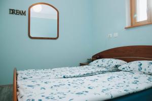 een slaapkamer met een bed met een spiegel aan de muur bij Apartment Kapitan With Climbing Wall in Kobarid
