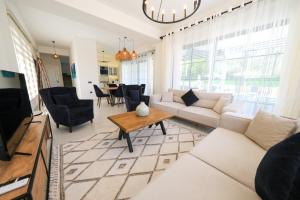 un salon avec un canapé blanc et une table dans l'établissement Misty Mountain Luxury Villa Fethiye, Yesiluzumlu by Sunworld Villas, à Fethiye