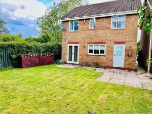 a brick house with a lawn in the yard at Luxury 4 bed house in Coventry in Coventry