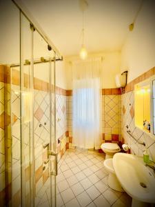 ein Bad mit einer Dusche, einem WC und einem Waschbecken in der Unterkunft Minturnae Hotel in Scauri