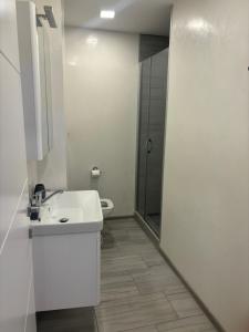 a white bathroom with a sink and a shower at Maja Apartmani in Sutomore +7 photos