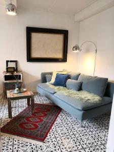 a living room with a blue couch and a table at Alte Schusterei direkt am Fluss und Altstadt in Oberndorf