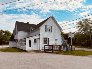 a white house with a man standing in front of it at Mackenzie Motel & Cottages in Shelburne