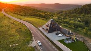 an overhead view of a house with a car parked next to a road at Pyramids Haven in Rîmeţi