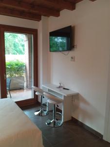 - une chambre avec un bureau et une télévision murale dans l'établissement Bes Residence Bergamo Polaresco, à Bergame