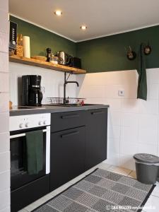 a kitchen with a black and white stove top oven at Alte Schusterei direkt am Fluss und Altstadt in Oberndorf