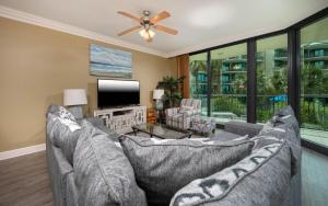 a living room with two gray couches and a tv at Phoenix on the Bay 1214 condo in Orange Beach