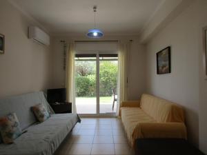 a living room with a couch and a sliding glass door at Vivere Apartment Barbati Beach in Barbati