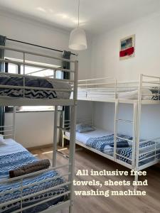 Pokój z 3 łóżkami piętrowymi i lampką zawieszoną w obiekcie Pirata hostel Milfontes w mieście Vila Nova de Milfontes