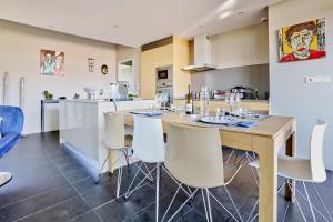 une cuisine et une salle à manger avec une table et des chaises dans l'établissement Sérénité au fil de l'eau Appartement de standing, à LʼIsle-sur-la-Sorgue