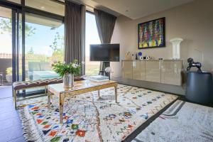 un salon avec une table et une télévision dans l'établissement Sérénité au fil de l'eau Appartement de standing, à LʼIsle-sur-la-Sorgue