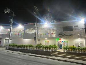 a building with lights on the side of it at night at Hotel Tamaiti in Ríohacha