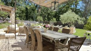 - une table et des chaises en bois dans le jardin dans l'établissement Villa Céladon Valbonne - Piscine, à Valbonne