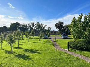 a park with trees and cars parked in the grass at Applin Lodge in Coldingham