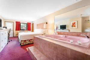a hotel room with a large tub and a bed at Aloha Beach Resort in Wisconsin Dells +56 photos