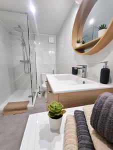 Un baño con bañera, lavabo y espejo. en Duplex Le Chai de l'Abreuvoir, en Saintes