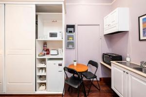 een kleine keuken met een tafel en 2 stoelen bij Dawson Accommodation in Fremantle