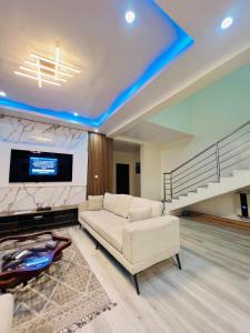 Una sala de estar con un sofá blanco y un televisor. en Elegant Living, en Lekki