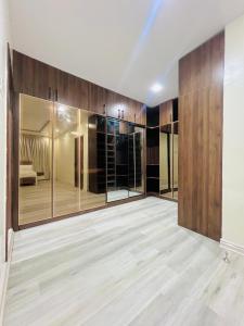 Una habitación vacía con puertas de cristal y paredes de madera. en Elegant Living, en Lekki