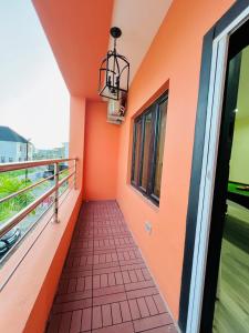 Un balcón con paredes naranjas y una pasarela. en Elegant Living, en Lekki