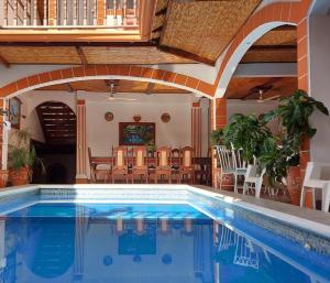 a pool in a house with chairs and a table at Hotel La Gran Sultana in Granada