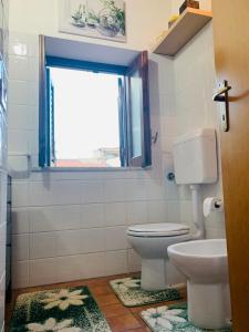 a bathroom with a toilet and a window at Cathedral House in Palermo