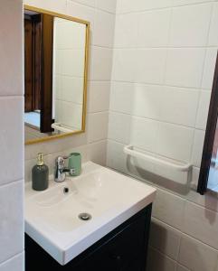 a bathroom with a white sink and a mirror at Cathedral House in Palermo
