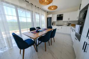 une cuisine avec une table en bois et des chaises bleues dans l'établissement Perfumed Garden Luxury Villa Yesiluzumlu-Fethiye by Sunworld Villas, à Fethiye