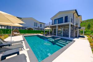 une piscine devant une maison dans l'établissement Perfumed Garden Luxury Villa Yesiluzumlu-Fethiye by Sunworld Villas, à Fethiye