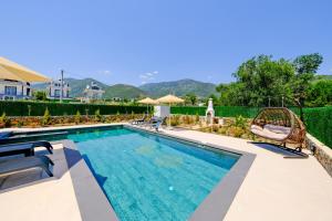 une grande piscine avec des chaises dans l'établissement Perfumed Garden Luxury Villa Yesiluzumlu-Fethiye by Sunworld Villas, à Fethiye
