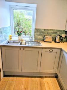 a kitchen with a sink and a window at Sterennyk in Helston