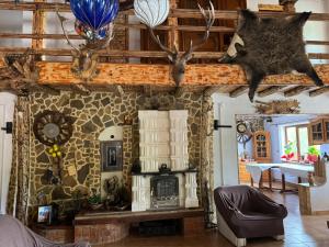 a living room with a fireplace and antlers on the wall at Căsuțele din pădure in Buzău