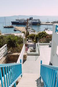 a dock with two blue benches and a cruise ship at Amuse Mykonos Boutique Hotel in Mýkonos City