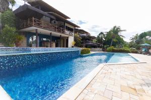 a swimming pool in front of a house at Chalé em Pipa por Carpediem in Pipa