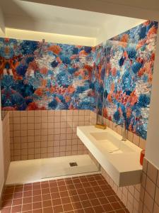 La salle de bains est pourvue d'un lavabo et d'un mur coloré. dans l'établissement Cefalhub, à Cefalù