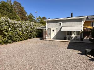 une maison avec une allée en gravier à côté d'un bâtiment dans l'établissement Kojan, à Vaxholm