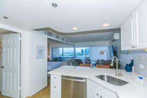 een keuken met witte kasten en een wastafel bij Ilikai Tower 1041 Yacht Harbor View 1BR in Honolulu