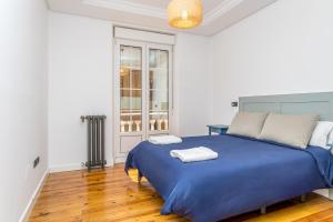 レオンにあるBaruHaus Santo Domingoの青いベッドと2枚のタオルが置かれた寝室